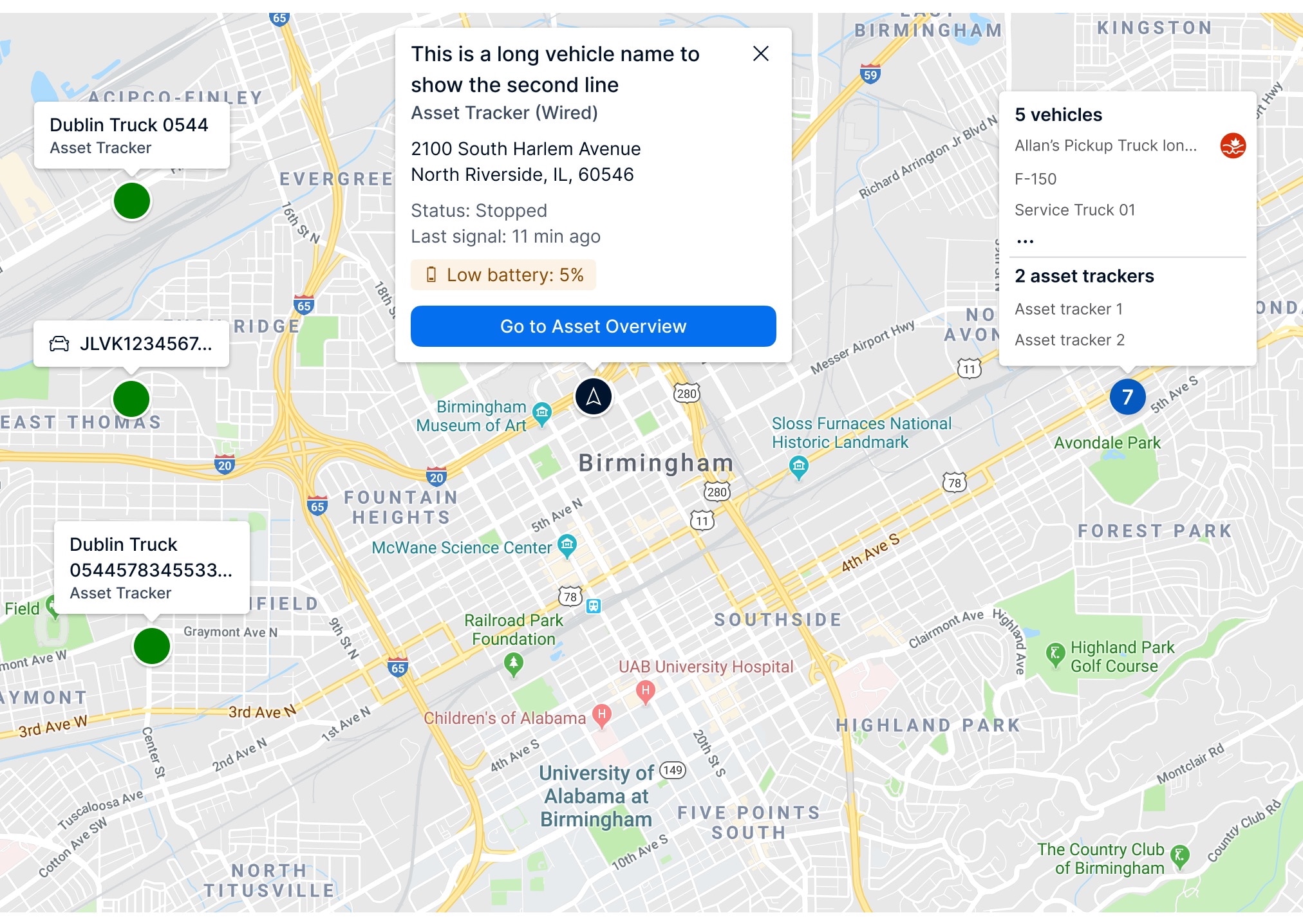 A map of Birmingham displaying several vehicle and asset tracker icons with one vehicle detail box open showing its name, address, and battery level. A sidebar on the right lists grouped assets and vehicles to improve navigation visibility.